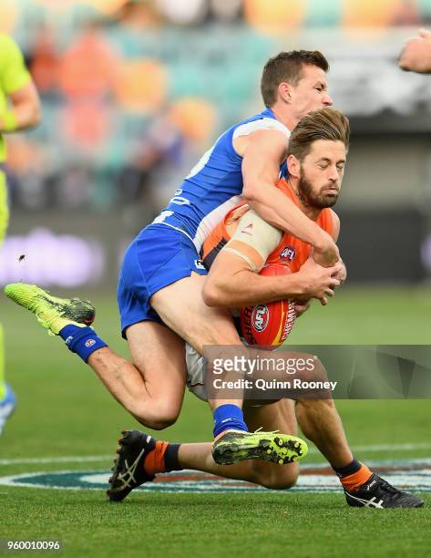 Callan Ward of the Giants is tackled by Kayne Turner of the Kangaroos during the round nine AFL match between the North Melbourne Kangaroos and the...