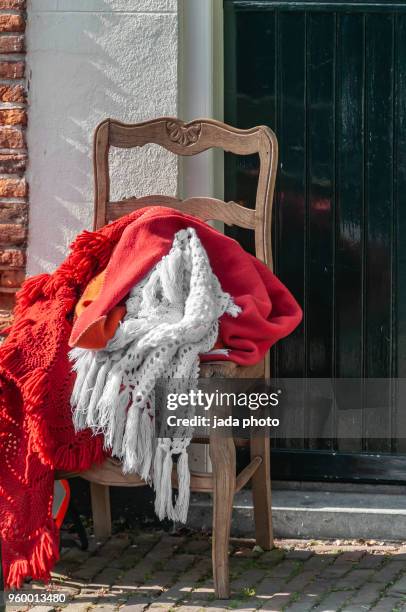 wooden chair with various colours of blankets - haarlem stock pictures, royalty-free photos & images