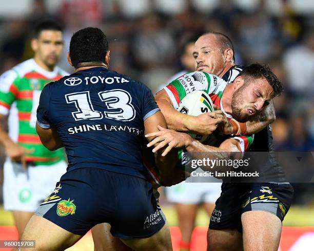 Sam Burgess of the Rabbitohs is tackled by Matthew Scott and Jason Taumalolo of the Cowboys during the round 11 NRL match between the North...