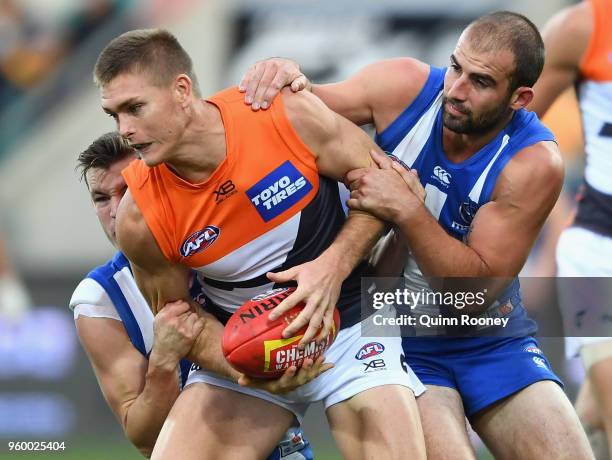 Adam Tomlinson of the Giants is tackled by Kayne Turner and Ben Cunnington of the Kangaroos during the round nine AFL match between the North...