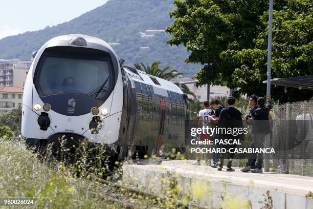 Students wait for the train at a railway stop on May 11, 2018 in Ajaccio on the French Mediterranean island of Corsica.