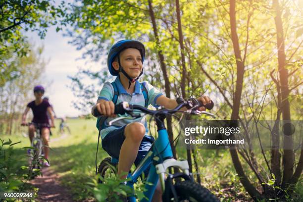 kleine jongen en zijn familie paardrijden fietsen in de natuur - familie fietsen close up stockfoto's en -beelden