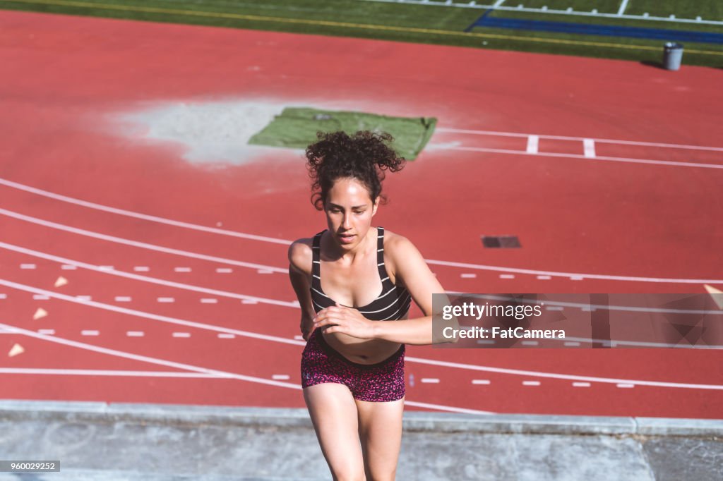 Female athlete cross trains on stadium stairs