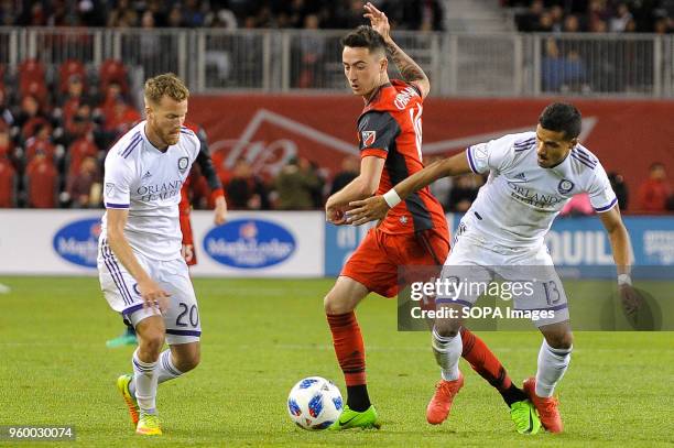 Jay Chapman between two rivals during 2018 MLS Regular Season match between Toronto FC and Orlando City SC at BMO Field .