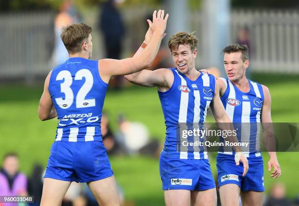 Trent Dumont of the Kangaroos is congratulated by team mates after kicking a goal during the round nine AFL match between the North Melbourne...