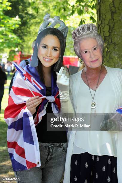 Members of the public, wearing masks of Meghan Markle and Queen Elizabeth II, are seen ahead of the wedding of Prince Harry to Ms. Meghan Markle at...