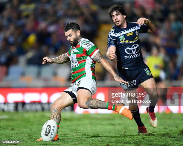 Adam Reynolds of the Rabbitohs attempts a field goal despite the pressure from Jake Granville of the Cowboys during the round 11 NRL match between...