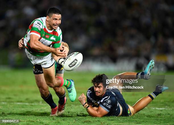 Cody Walker of the Rabbitohs gets a pass away despite the tackle of Jake Granville and Enari Tuala of the Cowboys during the round 11 NRL match...