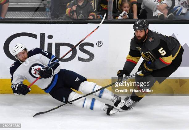 Toby Enstrom of the Winnipeg Jets falls after trying to block a pass by Deryk Engelland of the Vegas Golden Knights in the third period of Game Four...