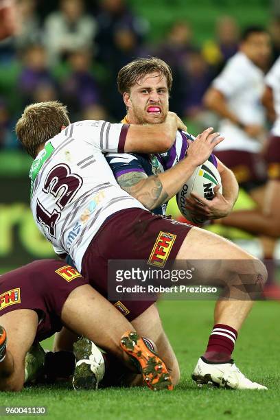 Cameron Munster of the Melbourne Storm is tackled during the round 11 NRL match between the Melbourne Storm and the Manly Sea Eagles at AAMI Park on...