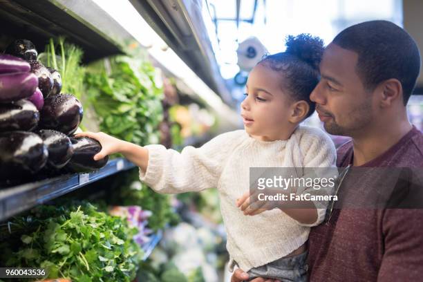 vader neemt zijn jonge dochter boodschappen te doen - supermarket fruit stockfoto's en -beelden
