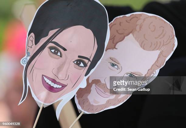 Fan holds renditions of Prince Harry and Meghan Markle she had downloaded and printed from the Internet at a public viewing where poeple came to...