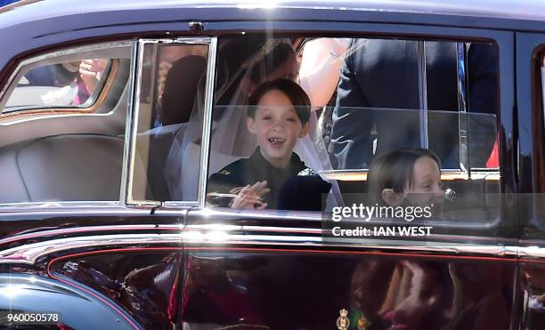 Page boys John and Brian Mulroney accompany US actress Meghan Markle as she arrives in a car for the wedding ceremony to marry Britain's Prince...