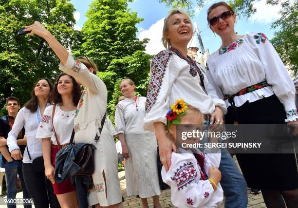 People wearing vyshyvankas, the traditional Ukrainian embroidered blouses, pose for a photograph during the Vyshyvankas March in Kiev on May 19,...