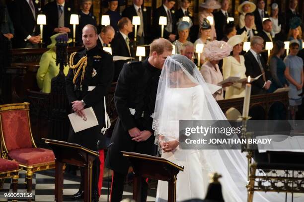 Britain's Prince Harry, Duke of Sussex, and US fiancee of Britain's Prince Harry Meghan Markle arrive at the High Altar for their wedding ceremony in...