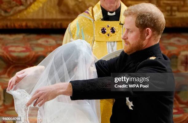 Prince Harry lifts the veil of Meghan Markle during their wedding ceremony in St George's Chapel at Windsor Castle on May 19, 2018 in Windsor,...