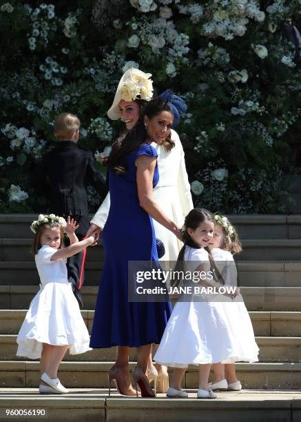 Britain's Catherine, Duchess of Cambridge and Meghan Markle's friend, Canadian fashion stylist Jessica Mulroney hold bridesmaids hands as they arrive...