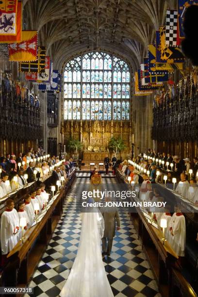 Britain's Prince Charles, Prince of Wales leads US fiancee of Britain's Prince Harry, Meghan Markle up the aisle of St George's Chapel for the...