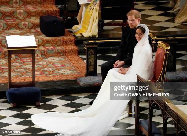 Britain's Prince Harry, Duke of Sussex sits with US actress Meghan Markle during the reading in St George's Chapel, Windsor Castle, in Windsor, on...