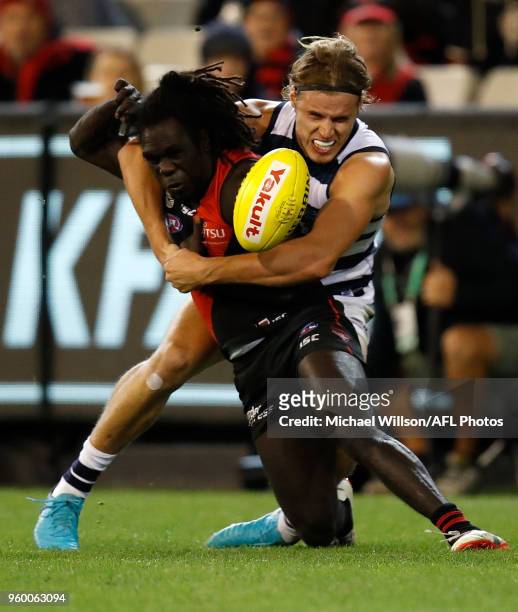 Anthony McDonald-Tipungwuti of the Bombers is tackled by Jake Kolodjashnij of the Cats during the 2018 AFL round nine match between the Essendon...