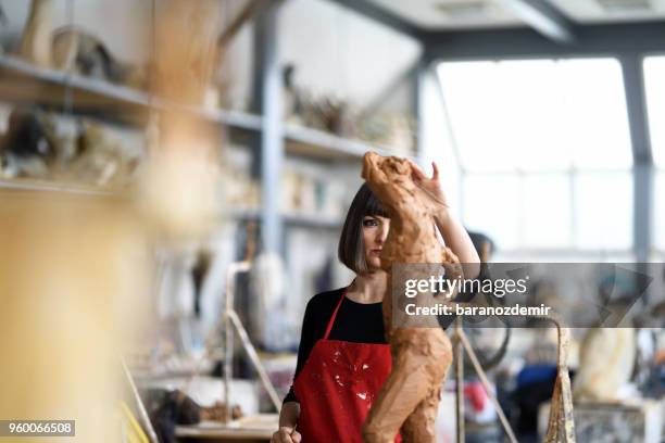 young female sculptor is working in her studio - fine art statue stock pictures, royalty-free photos & images