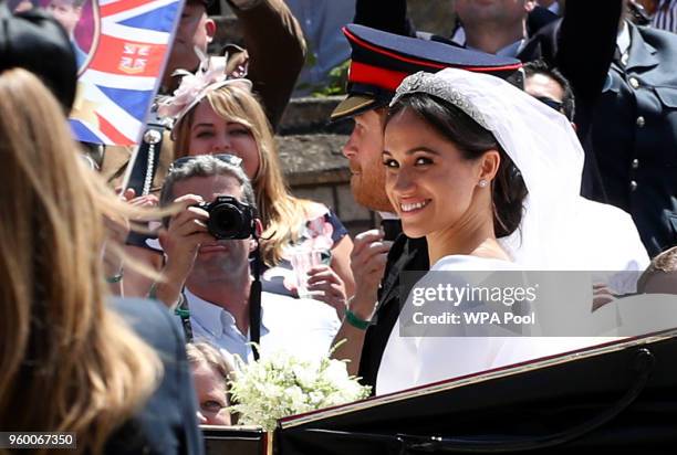 Prince Harry, Duke of Sussex and The Duchess of Sussex ride in the Ascot Landau carriage during the procession after getting married St George's...