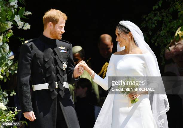 Britain's Prince Harry, Duke of Sussex and his wife Meghan, Duchess of Sussex emerge from the West Door of St George's Chapel, Windsor Castle, in...
