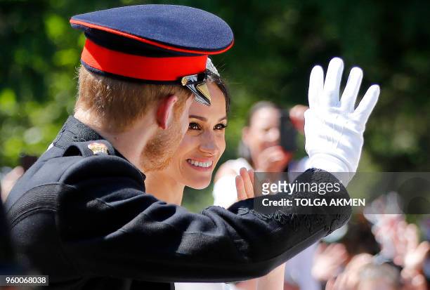 Britain's Prince Harry, Duke of Sussex and his wife Meghan, Duchess of Sussex wave from the Ascot Landau Carriage during their carriage procession on...