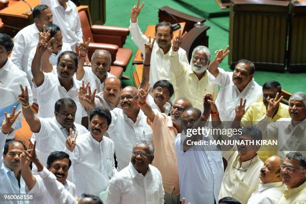 Newly elected members of the Karnataka State Legislative Assembly belonging to Congress and Janatha Dal gesture after the Chief Minister B.S....