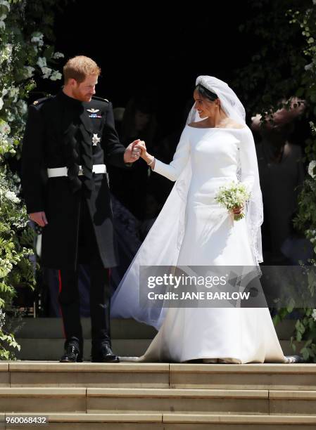 Britain's Prince Harry, Duke of Sussex and his wife Meghan, Duchess of Sussex emerge from the West Door of St George's Chapel, Windsor Castle, in...