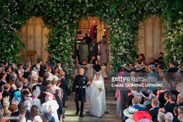 Britain's Prince Harry, Duke of Sussex and Britain's Meghan Markle, Duchess of Sussex, walk back down the aisle away from the High Altar as they...