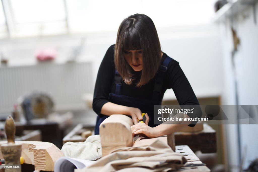 年輕的女雕刻家在她的工作室工作