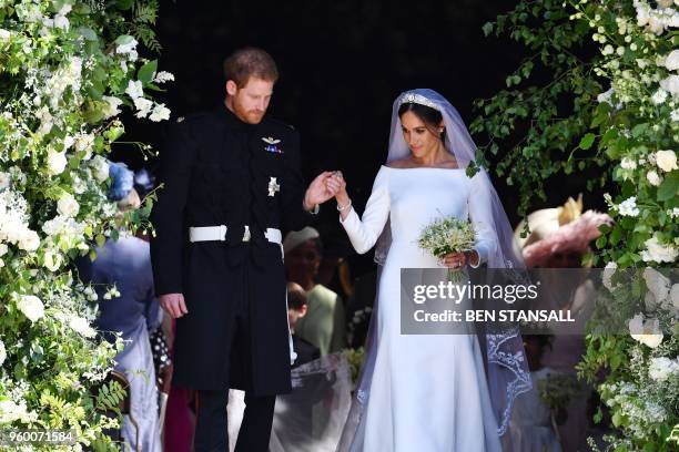 Britain's Prince Harry, Duke of Sussex and his wife Meghan, Duchess of Sussex emerge from the West Door of St George's Chapel, Windsor Castle, in...