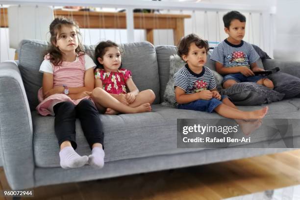 children watching tv/film together - rafael ben ari stock pictures, royalty-free photos & images