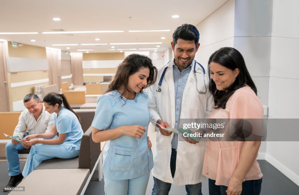 Mujer paciente mirando un folleto el médico y la enfermera están mostrando a ella en la sala de espera