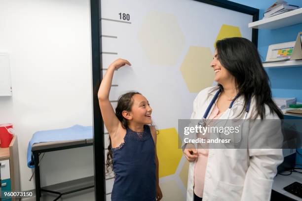 playful little girl with doctor having fun while pediatrician is measuring her and both laughing - high up stock pictures, royalty-free photos & images
