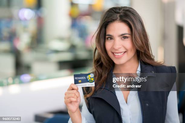 beautiful female employee of a hotel wearing uniform and holding a loyatly rewards program card - travel loyalty stock pictures, royalty-free photos & images