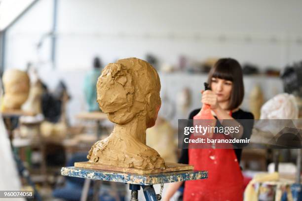 la giovane scultrice sta lavorando nel suo studio - baranozdemir foto e immagini stock