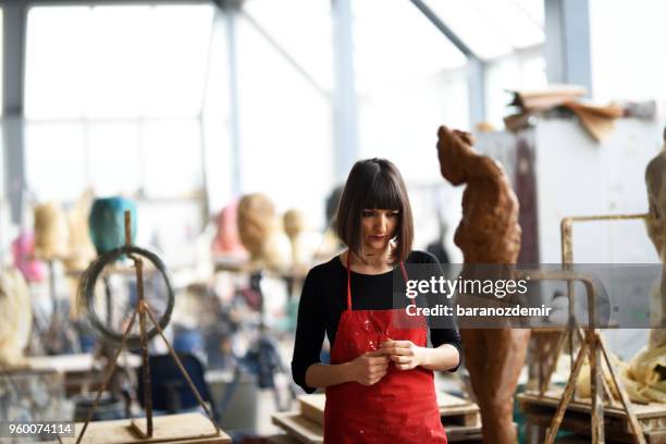 la giovane scultrice sta lavorando nel suo studio - baranozdemir foto e immagini stock