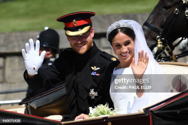 Britain's Prince Harry, Duke of Sussex and his wife Meghan, Duchess of Sussex wave from the Ascot Landau Carriage during their carriage procession on...