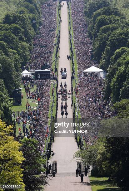 Britain's Prince Harry, Duke of Sussex and his wife Meghan, Duchess of Sussex, are escorted by members of the Household Cavalry Mounted Regiment as...