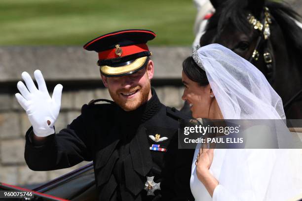 Britain's Prince Harry, Duke of Sussex and his wife Meghan, Duchess of Sussex travel in the Ascot Landau Carriage during their carriage procession on...