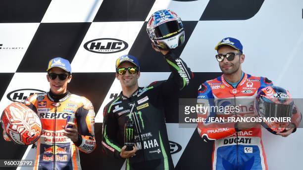 Monster Yamaha Tech 3's French rider Johann Zarco celebrates on the podium after he clocked the pole position ahead of Repsol Honda Team's Spanish...
