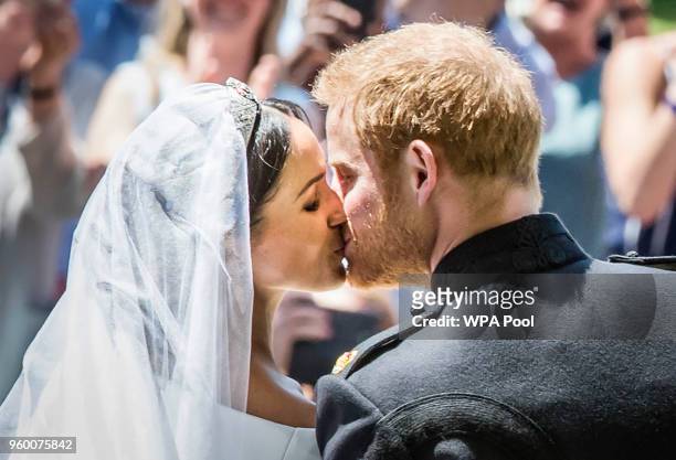Prince Harry, Duke of Sussex and The Duchess of Sussex kiss on the steps of St George's Chapel in Windsor Castle after their wedding on May 19, 2018...