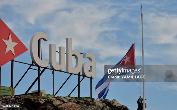 The Cuban national flag is raised at half-mast in tribute to the victims of a plane that crashed shortly after taking off from Jose Marti airport and...