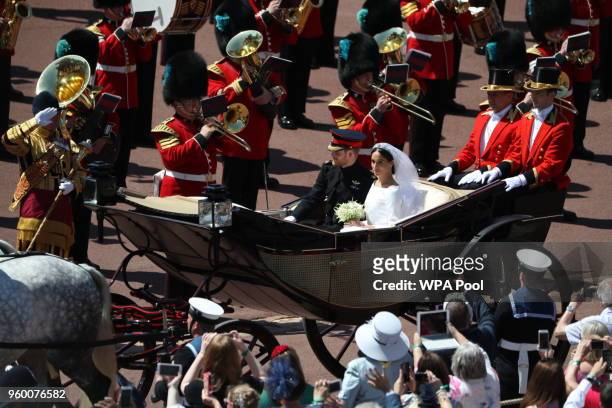 Prince Harry, Duke of Sussex and The Duchess of Sussex ride in the Ascot Landau carriage during a procession after getting married at St Georges...
