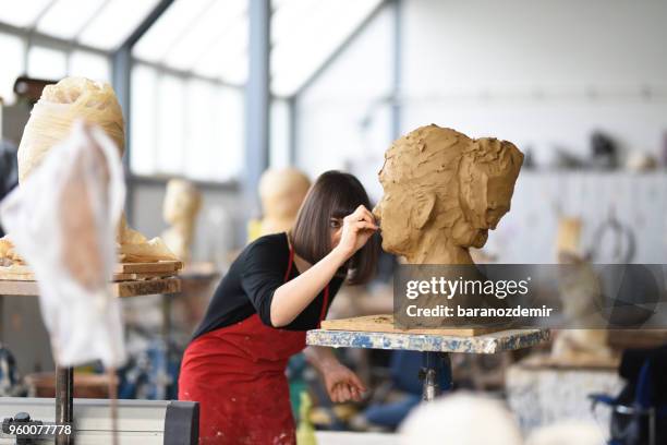 la giovane scultrice sta lavorando nel suo studio - baranozdemir foto e immagini stock