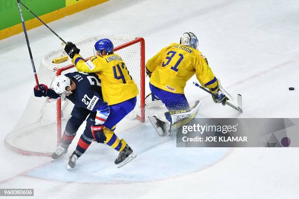 Sweden's Hampus Lindholm and Sweden's goalie Anders Nilsson vie with United States' Anders Lee during the semifinal match Sweden vs USA of the 2018...