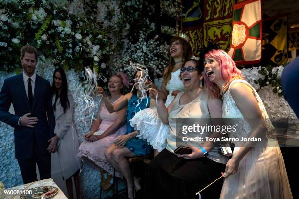 Attendees watch a live broadcast of the Royal Wedding between UK's Prince Harry, Duke of Sussex, and Meghan Markle, Duchess of Sussex, during a...
