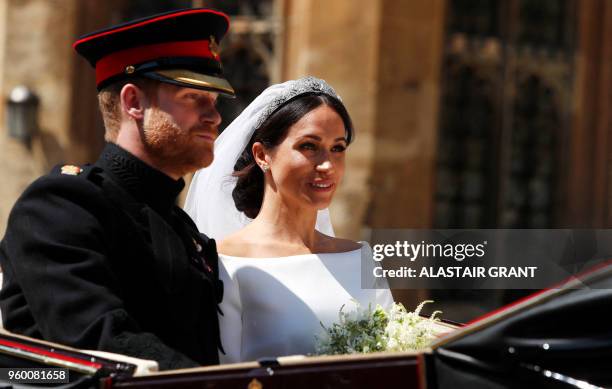 Britain's Prince Harry, Duke of Sussex and his wife Meghan, Duchess of Sussex ride in the Ascot Landau Carriage at the start of their procession...